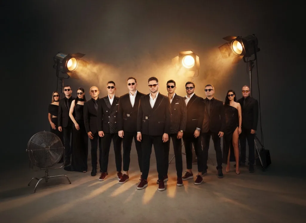 CHEGI BEND — ceo sastav u crnim odelima i haljinama, u studiju sa reflektorima